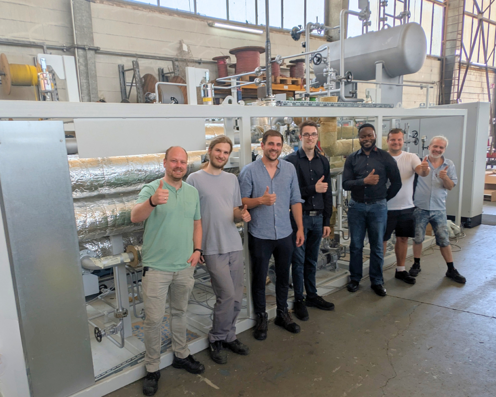 Mehrere Personen stehen vor der 450°C-Anlage